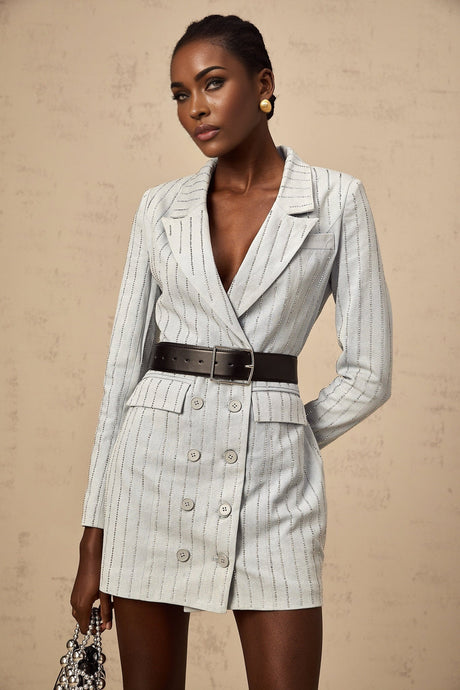 Woman wearing blue denim mini dress with rhinestone embellishments and blazer style collar and lapels