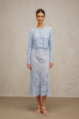 Woman wearing blue floral lace matching top and skirt set with delicate pattern and feminine design
