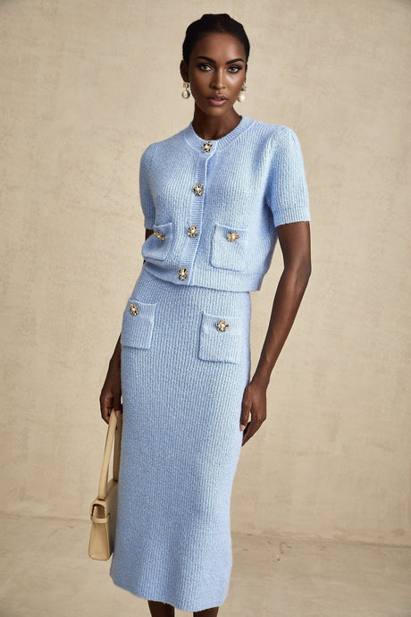 Woman wearing blue knit matching set with long sleeve blouse and knee length skirt