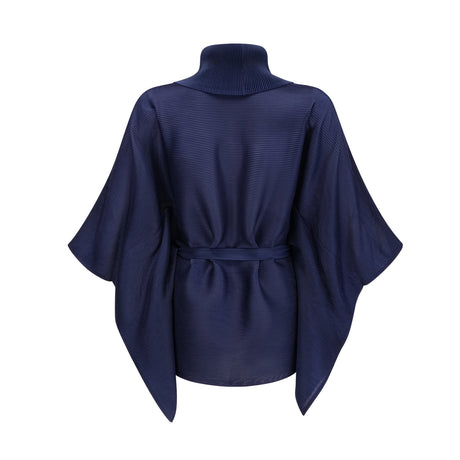 Woman wearing blue patterned cape and matching skirt set with creased texture and allover print design
