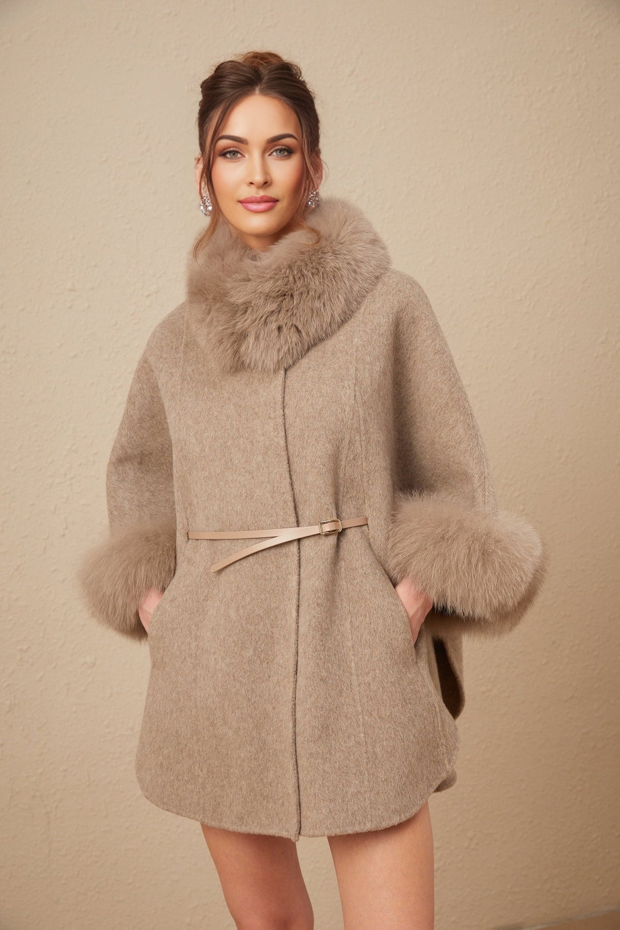 Woman wearing brown wool cape coat with fur trim and belt cinched at waist