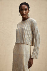 Woman wearing champagne colored striped knit top and matching skirt set