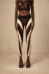 Woman wearing colorful spiral patterned leggings with color block panels in various shades