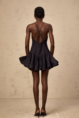 Woman wearing dark blue denim mini dress with flounce detail
