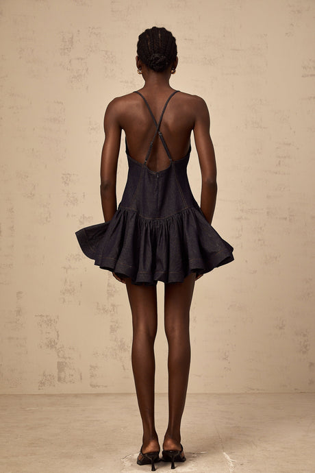 Woman wearing dark blue denim mini dress with flounce detail