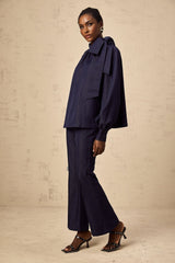 Woman wearing denim blue matching set with flared blouse and trousers called Mathilde