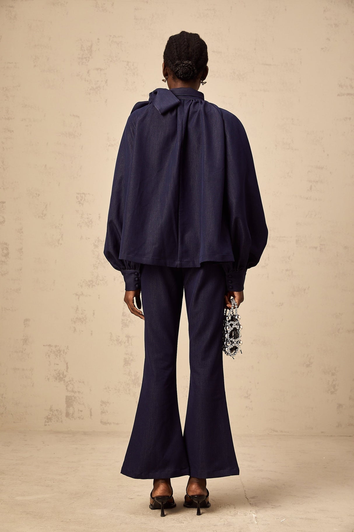 Woman wearing denim blue matching set with flared blouse and trousers called Mathilde
