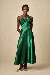 Woman wearing emerald green satin midi dress with open back design