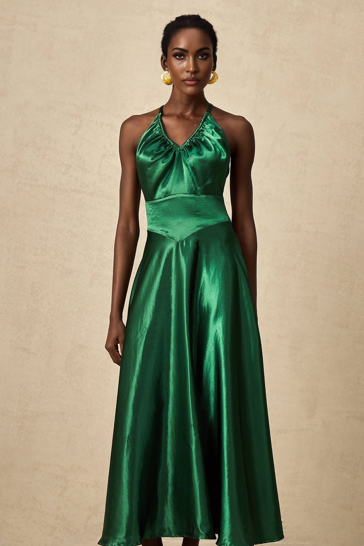 Woman wearing emerald green satin midi dress with open back design