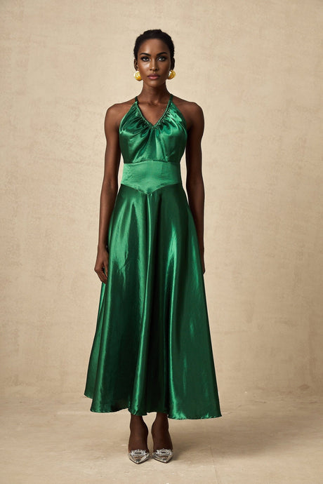 Woman wearing emerald green satin midi dress with open back design