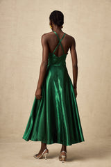Woman wearing emerald green satin midi dress with open back design