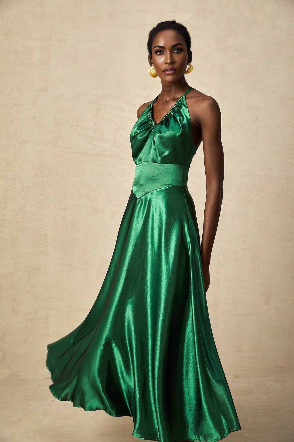 Woman wearing emerald green satin midi dress with open back design