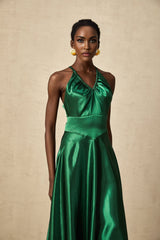 Woman wearing emerald green satin midi dress with open back detail