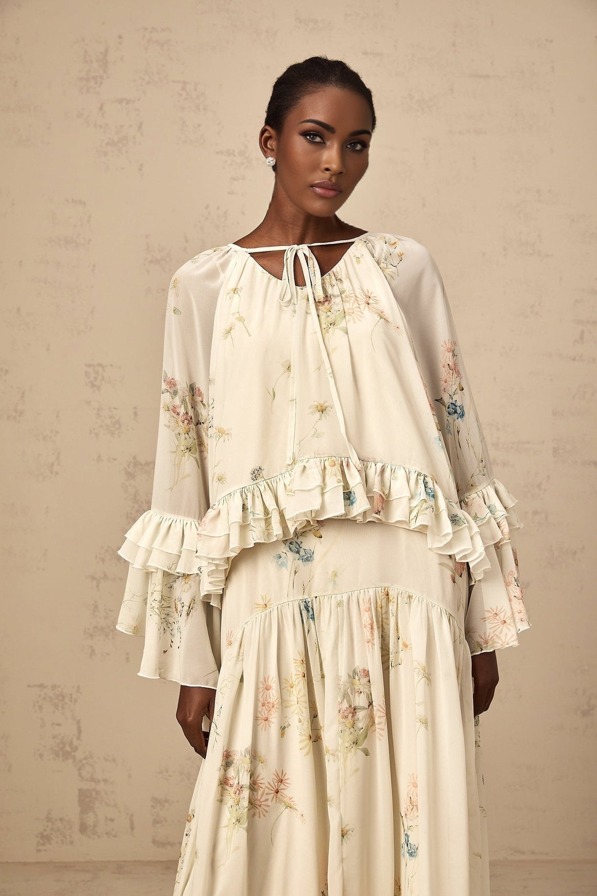 Woman wearing floral print matching blouse and dress set with ruffled details in Melissa style
