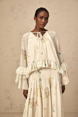 Woman wearing floral print matching blouse and dress set with ruffled details in Melissa style