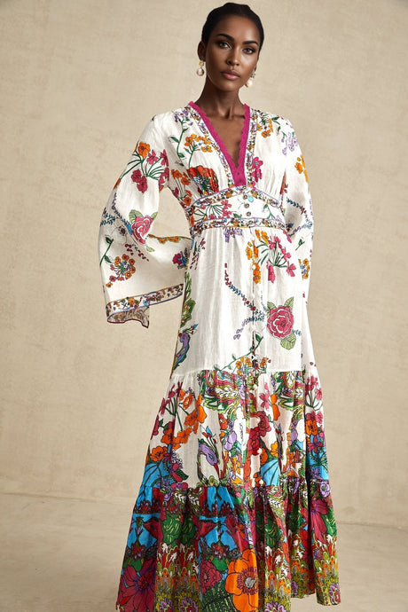 Woman wearing floral print midi dress with Vneck in pastel colors standing against plain background