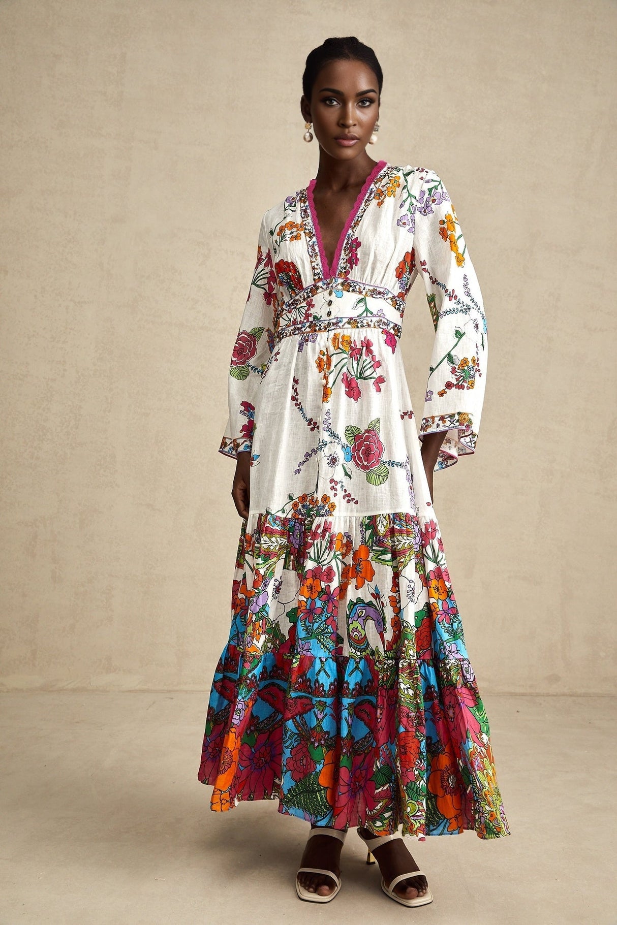 Woman wearing floral print midi dress with Vneck in soft colors standing against plain background