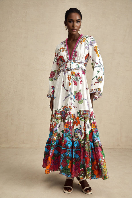 Woman wearing floral print midi dress with Vneck in soft colors standing against plain background