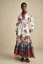 Woman wearing floral print midi dress with Vneck in soft colors standing against plain background