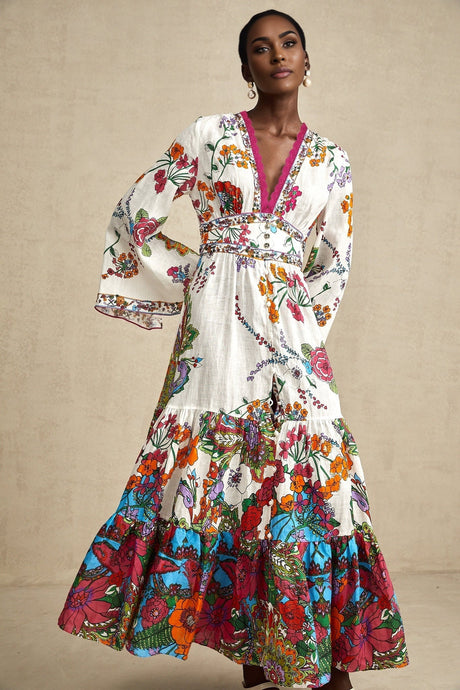 Woman wearing floral print midi dress with Vneck in soft pastel colors standing against plain background