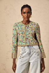 Woman wearing gold sequined tweed jacket with checkered pattern and gold tone accents