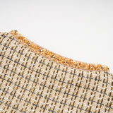 Woman wearing gold tweed jacket and matching skirt with sequin details elegant formal outfit set