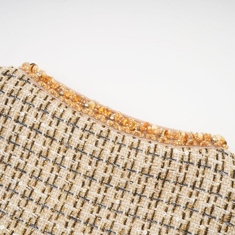 Woman wearing gold tweed jacket and matching skirt with sequin details elegant formal outfit set