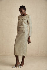 Woman wearing gold tweed jacket and matching skirt with sequin embellishments Elegant two piece set for formal occasions