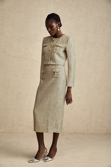 Woman wearing gold tweed jacket and matching skirt with sequin embellishments Elegant two piece set for formal occasions