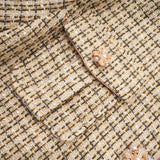 Woman wearing gold tweed jacket and matching skirt with sequin embellishments elegant two piece set for formal occasions