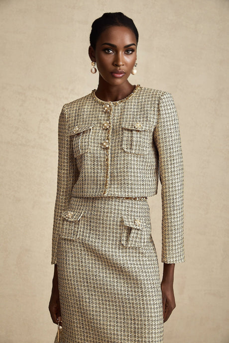 Woman wearing gold tweed jacket and matching skirt with sequin embellishments