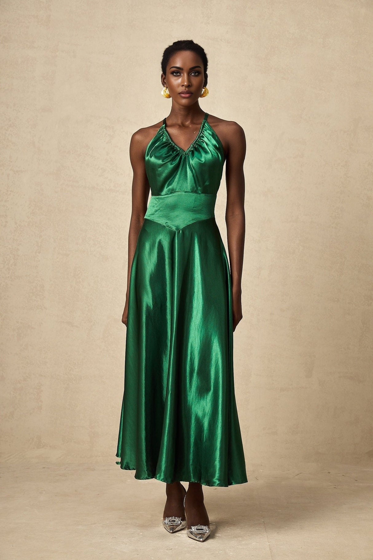 Woman wearing green emerald satin midi dress with open back design