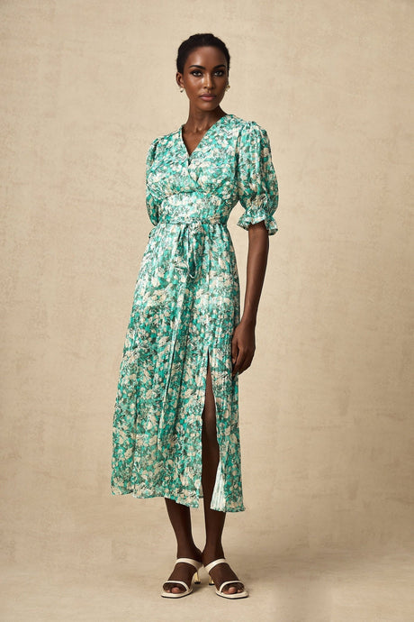 Woman wearing green midi dress with floral print and high slit standing in casual pose