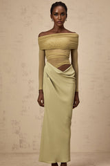 Woman wearing green offshoulder midi dress with semisheer fabric standing in relaxed pose