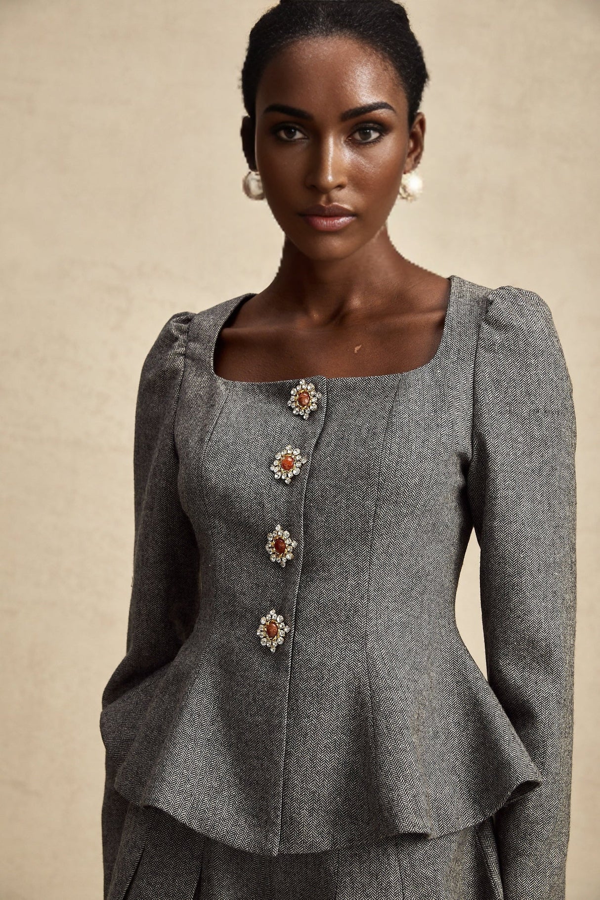 Woman wearing grey herringbone pattern matching top and shorts set named Agathe