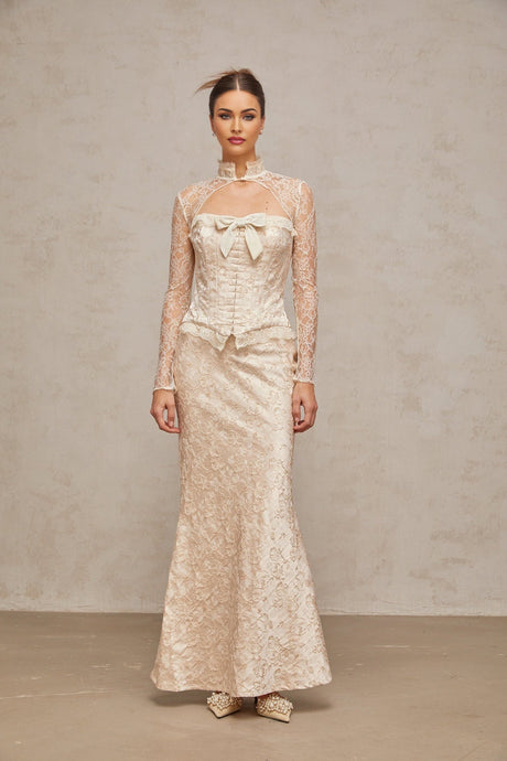 Woman wearing ivory colored matching top and skirt set with subtle patterned jacquard design