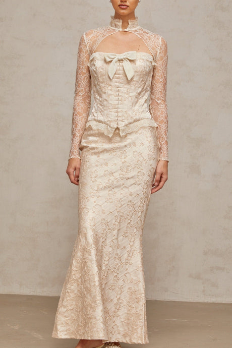 Woman wearing ivory two piece outfit with patterned jacquard fabric top and matching skirt
