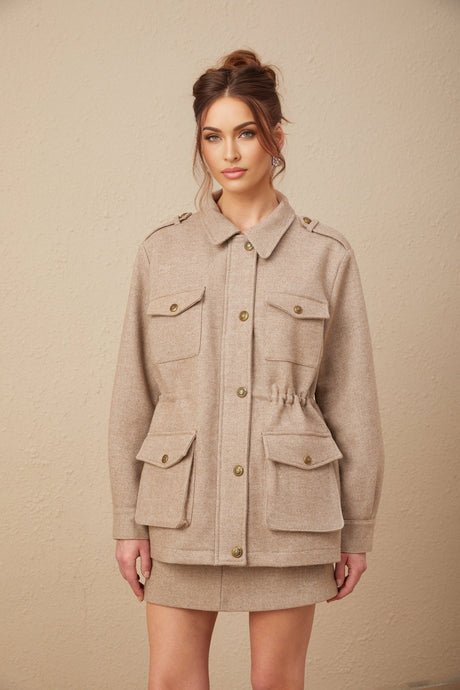 Woman wearing khaki wool twill jacket and matching culottes standing in neutral pose