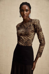 Woman wearing leopard print bodysuit with long sleeves and high neckline