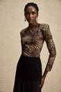 Woman wearing leopard print bodysuit with long sleeves and high neckline