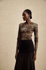 Woman wearing leopard print bodysuit with long sleeves and high neckline