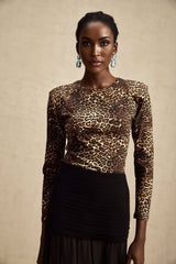 Woman wearing leopard print bodysuit with long sleeves and scoop neckline