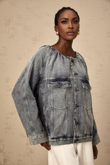 Woman wearing light blue collarless denim jacket with button front closure and chest pockets