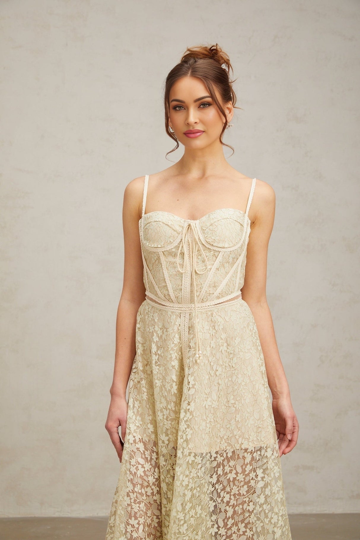 Woman wearing light green midi dress with floral embroidery pattern standing in neutral background