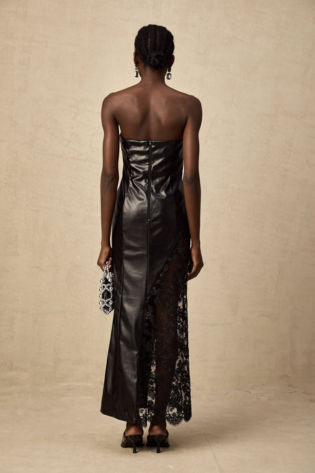 Woman wearing long black dress with lace panels and faux leather material floor length maxi style