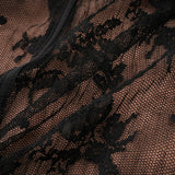 Woman wearing long black flared maxi dress with lace details
