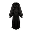 Woman wearing long black pleated satin maxi dress with flowing skirt and fitted bodice