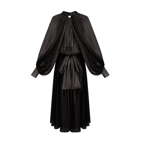 Woman wearing long black pleated satin maxi dress with flowing skirt and fitted bodice