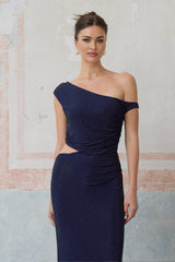 Woman wearing long blue maxi dress with rhinestone embellishments and cutout details