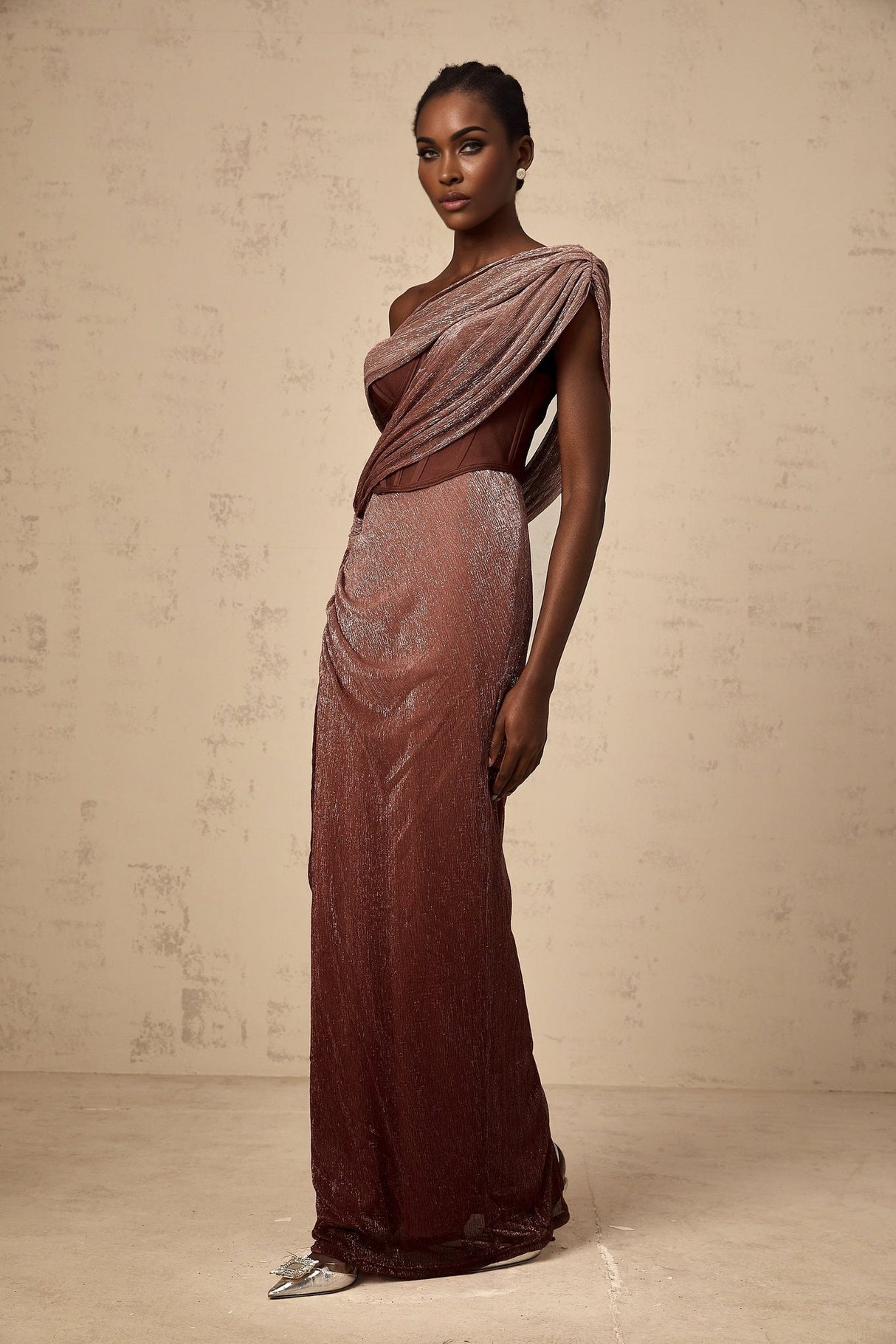 Woman wearing long brown maxi dress with corset top featuring ribbon design and flared skirt
